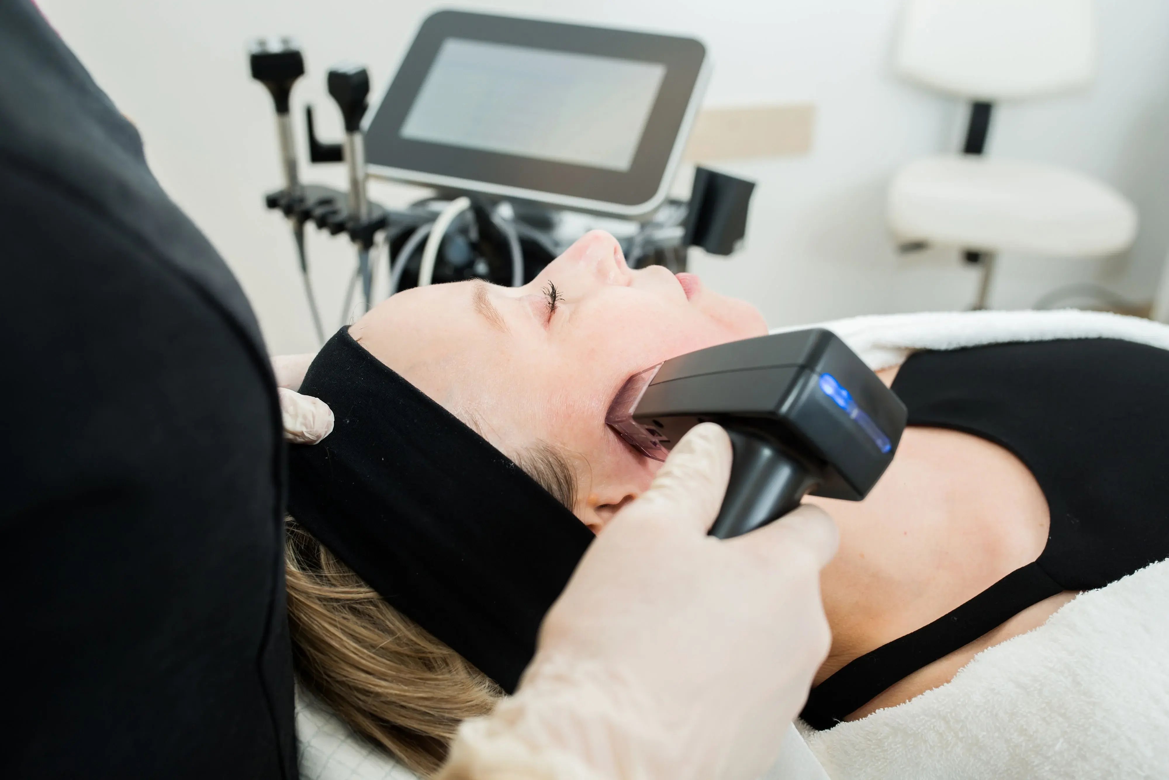 woman-receiving-facial-treatment-with-morpheus8-handpiece-while-lying-on-bed-showing-what-is-morpheus8-in-a-clinic-setting